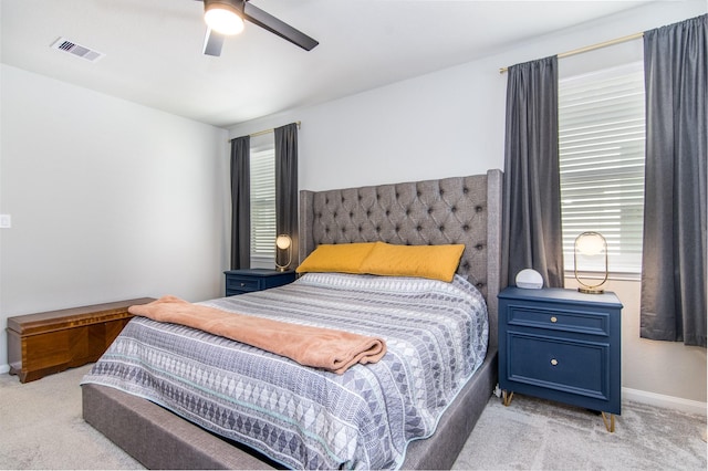 carpeted bedroom with ceiling fan and multiple windows