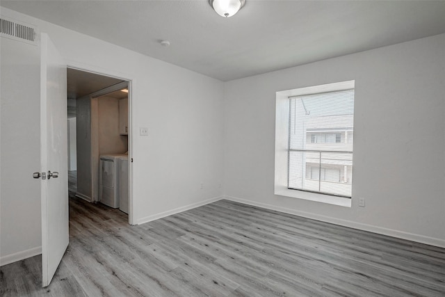 spare room with separate washer and dryer and light hardwood / wood-style floors