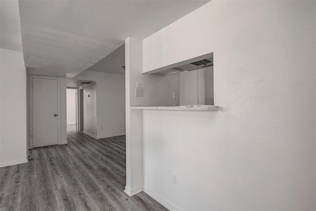 hallway with a textured ceiling and hardwood / wood-style floors