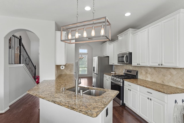 kitchen with stainless steel appliances, white cabinets, pendant lighting, and kitchen peninsula