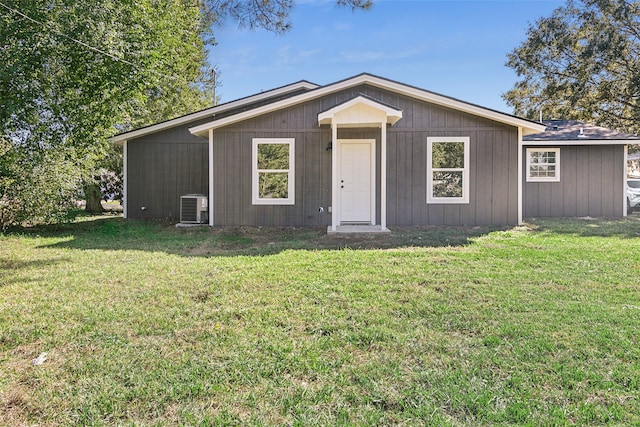 ranch-style home featuring central AC unit and a front lawn