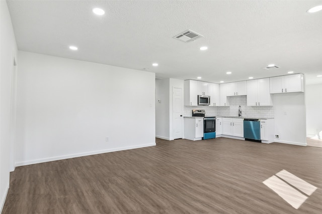 kitchen with stainless steel appliances, sink, white cabinetry, tasteful backsplash, and dark wood-type flooring