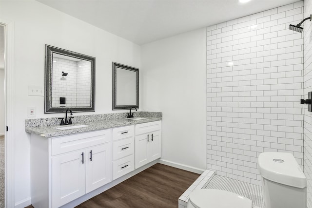 bathroom featuring vanity, a shower, hardwood / wood-style flooring, and toilet