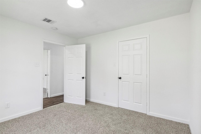 unfurnished bedroom with dark carpet