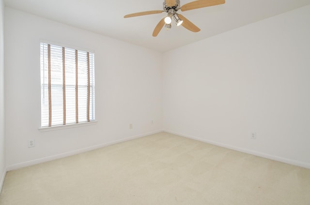 spare room with ceiling fan and light colored carpet