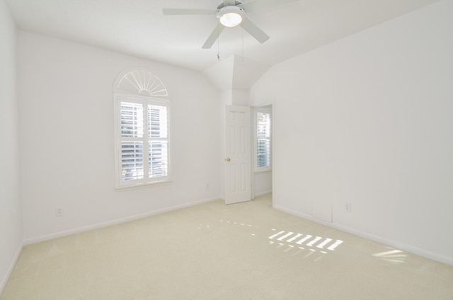 carpeted spare room with ceiling fan, lofted ceiling, and plenty of natural light