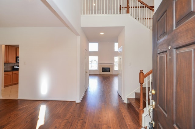 entrance foyer with hardwood / wood-style flooring and a towering ceiling