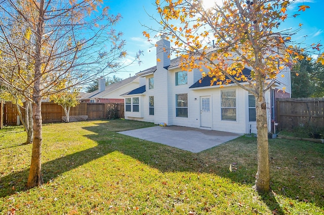 rear view of house with a patio area and a lawn