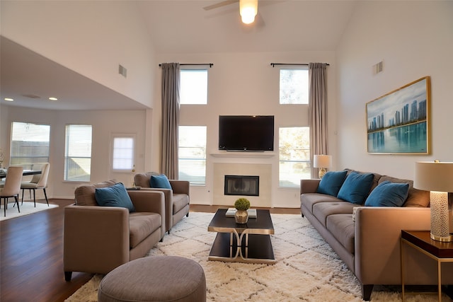 living room featuring light wood-type flooring, ceiling fan, a healthy amount of sunlight, and high vaulted ceiling