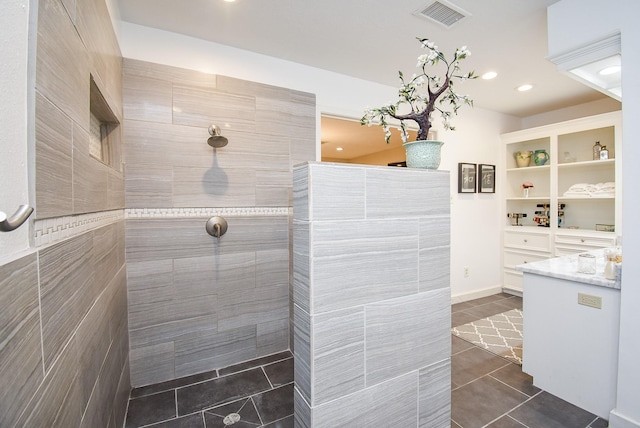 bathroom with tiled shower and tile patterned floors