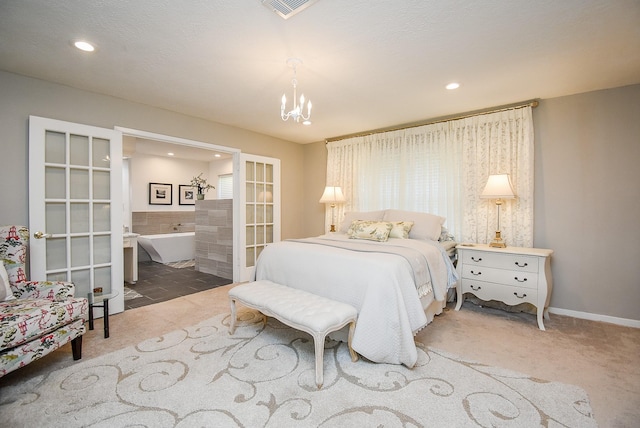 bedroom with ensuite bathroom, french doors, and a chandelier