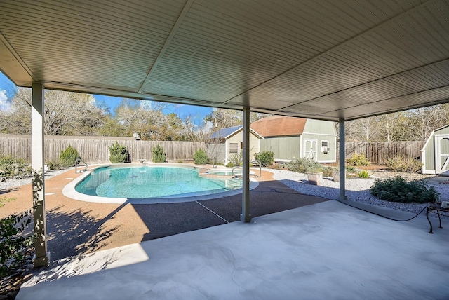 view of swimming pool with a patio area and a storage shed