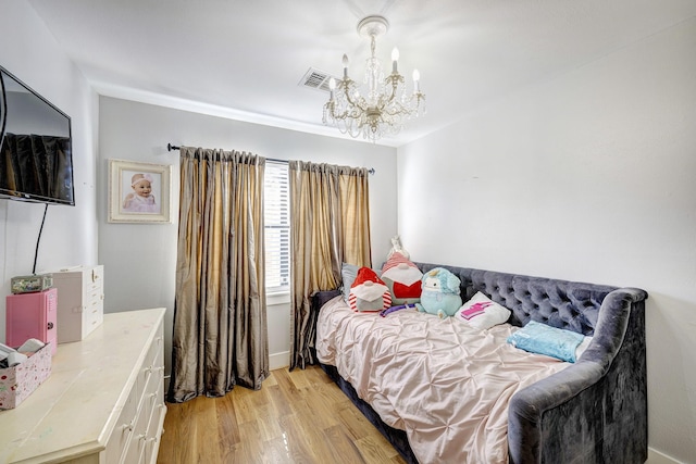 bedroom featuring light hardwood / wood-style flooring and a chandelier