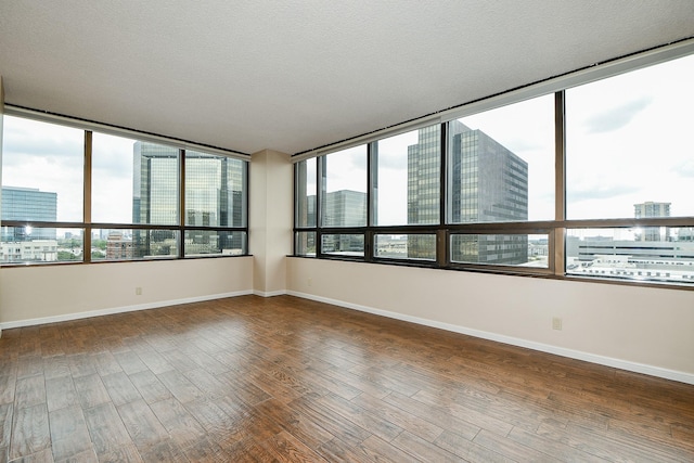 unfurnished room featuring a textured ceiling and hardwood / wood-style flooring