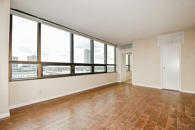 unfurnished room featuring a textured ceiling and hardwood / wood-style floors