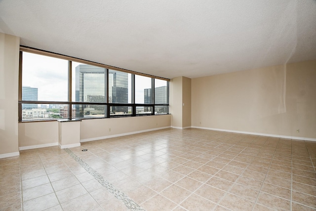 tiled empty room with a textured ceiling