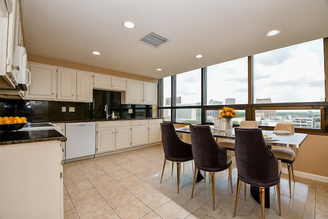 kitchen with white dishwasher, sink, a healthy amount of sunlight, and white cabinetry