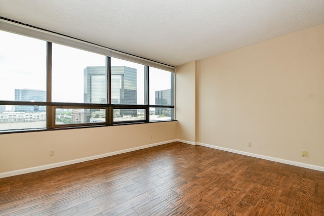 spare room with wood-type flooring and a textured ceiling