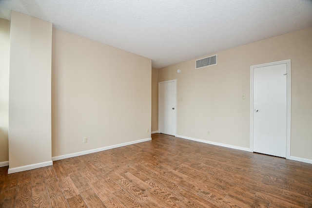 unfurnished room featuring a textured ceiling and hardwood / wood-style floors