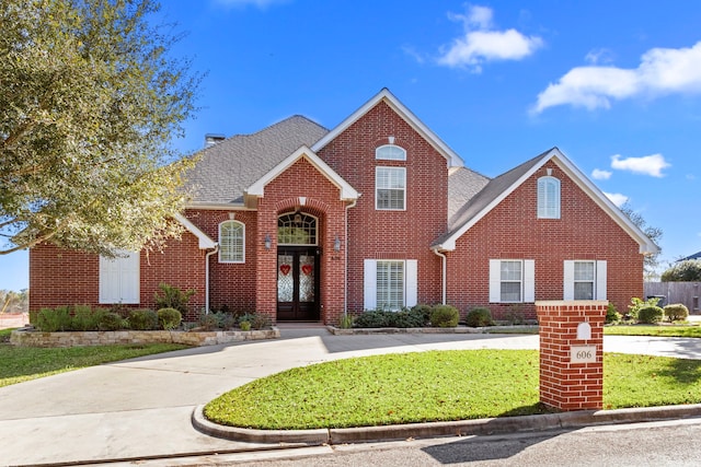 view of property featuring a front yard and french doors