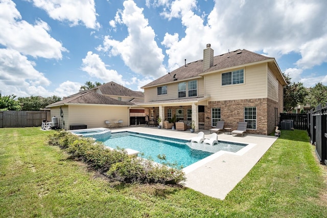 back of property featuring a pool with hot tub, a patio, a lawn, and central AC