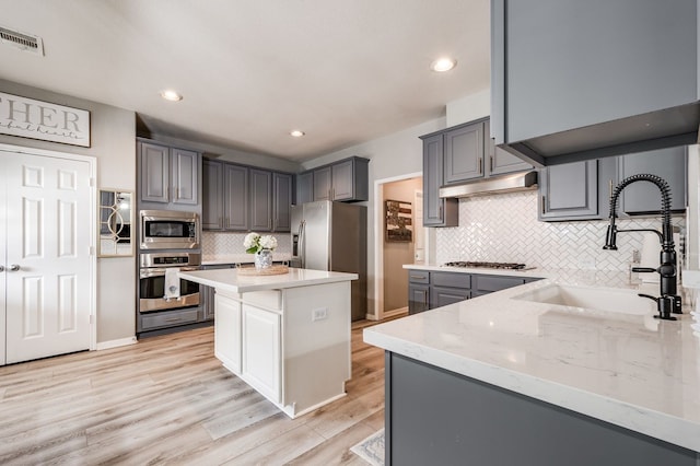 kitchen featuring sink, a kitchen island, gray cabinets, and appliances with stainless steel finishes