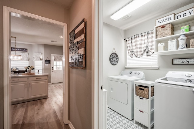 washroom with light hardwood / wood-style flooring and washing machine and dryer