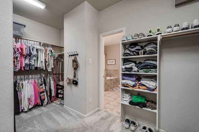 walk in closet featuring light carpet