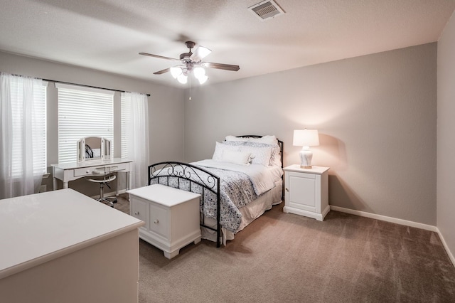 bedroom featuring ceiling fan, a textured ceiling, and dark colored carpet