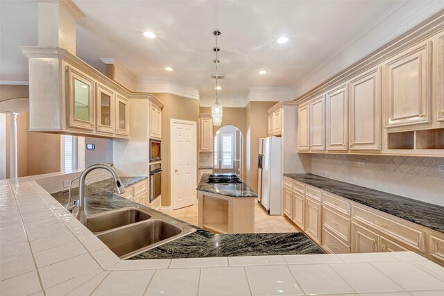 kitchen featuring decorative light fixtures, stainless steel appliances, tile countertops, and sink