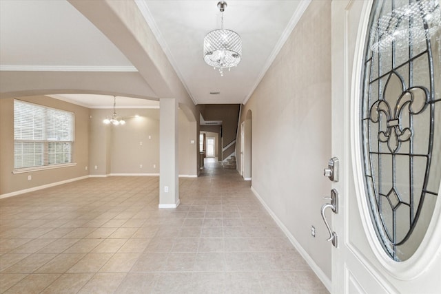 foyer featuring light tile patterned floors, a chandelier, a healthy amount of sunlight, and crown molding