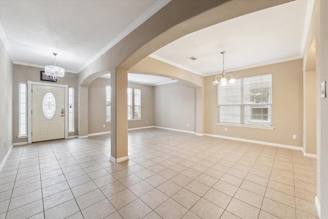 tiled foyer featuring a notable chandelier and crown molding