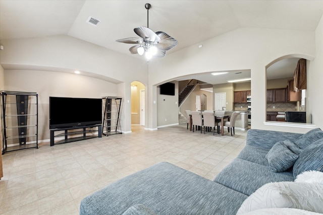 tiled living room with lofted ceiling and ceiling fan