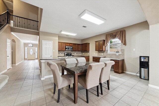 tiled dining area with sink and an inviting chandelier