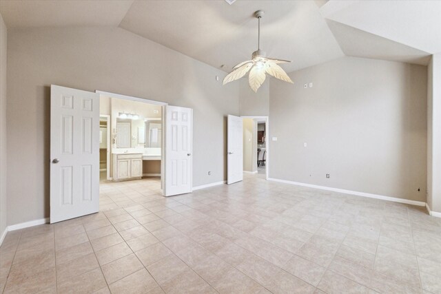 unfurnished bedroom featuring ceiling fan, light tile patterned flooring, connected bathroom, and lofted ceiling