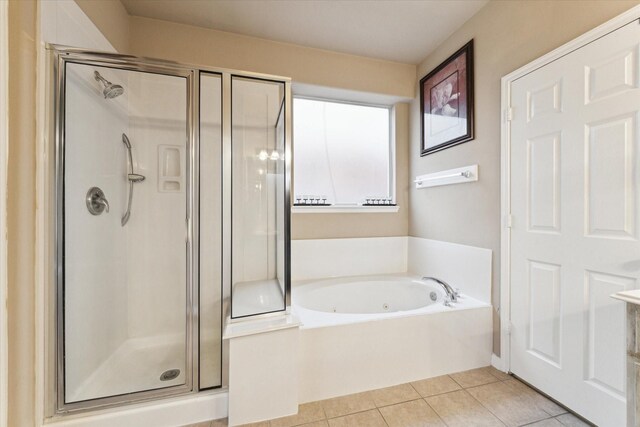 bathroom with independent shower and bath and tile patterned floors