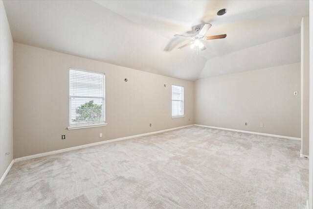 spare room with ceiling fan, light carpet, and vaulted ceiling