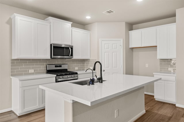 kitchen with an island with sink, appliances with stainless steel finishes, and sink