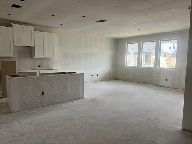 kitchen featuring white cabinetry, visible vents, and unfinished concrete floors