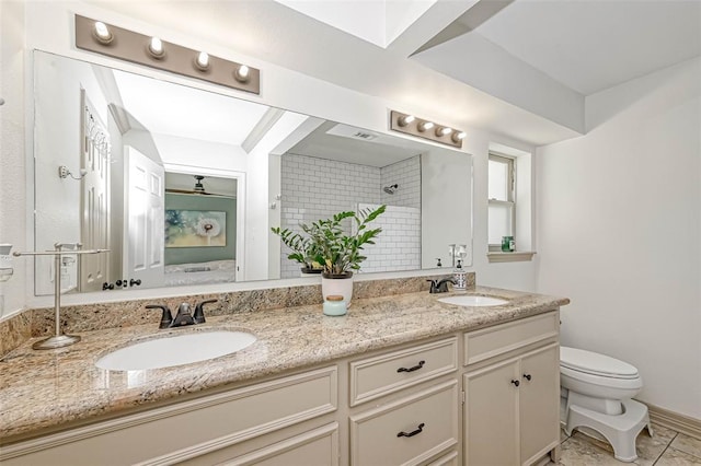 bathroom with tiled shower, tile patterned flooring, vanity, and toilet