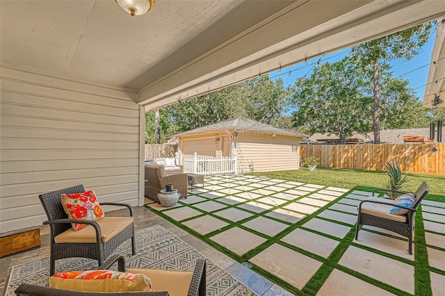 view of patio with a garage, an outdoor structure, and an outdoor living space