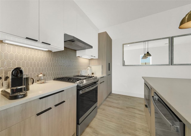 kitchen featuring stainless steel appliances, white cabinets, tasteful backsplash, light hardwood / wood-style flooring, and pendant lighting