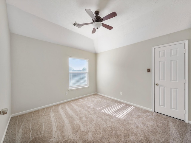 carpeted empty room featuring ceiling fan and lofted ceiling