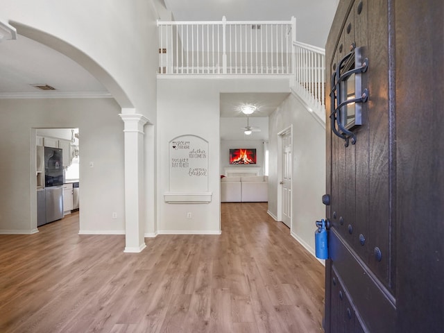 foyer with light hardwood / wood-style floors and crown molding