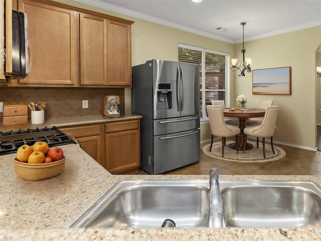 kitchen with tasteful backsplash, appliances with stainless steel finishes, ornamental molding, and pendant lighting