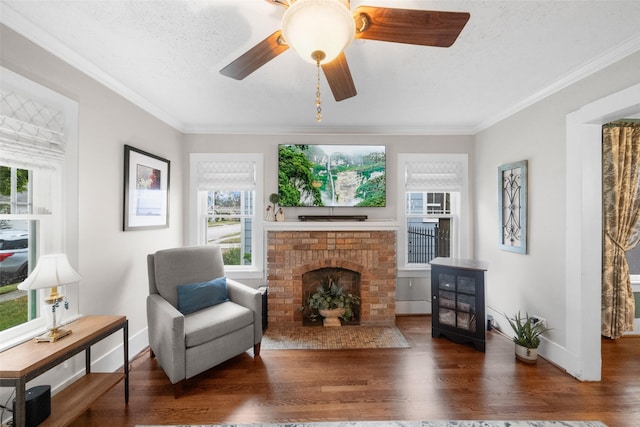 sitting room with a textured ceiling, dark wood-type flooring, and crown molding