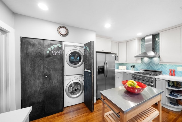 laundry room with light hardwood / wood-style floors and stacked washer and dryer