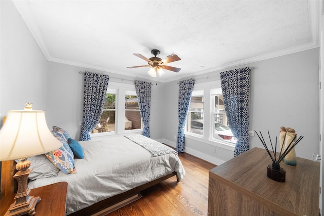 bedroom featuring ceiling fan, wood-type flooring, and crown molding