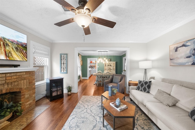 living room featuring a textured ceiling, ceiling fan, dark hardwood / wood-style flooring, and crown molding