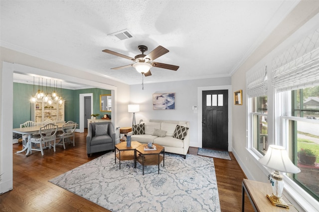 living room featuring a textured ceiling, crown molding, ceiling fan with notable chandelier, and dark hardwood / wood-style floors